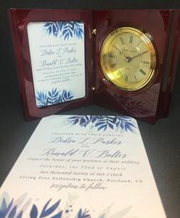 A wedding invitation and clock set up for the ceremony.