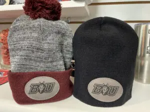 Two hats are shown on a shelf.