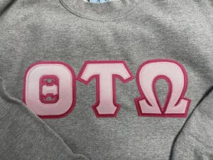 A grey shirt with pink letters on it