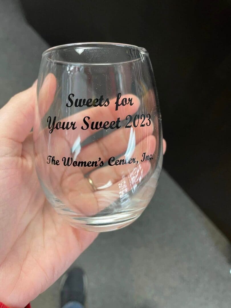 A person holding up a wine glass with the words " sweets for your sweet 2 0 1 9 ".