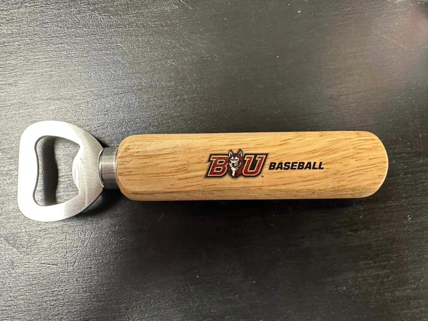 A wooden bottle opener with the baseball logo on it.